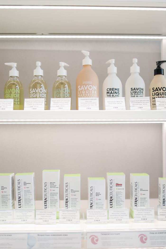 services-02 Elegant display of skincare products with bottles and boxes on illuminated shelves.